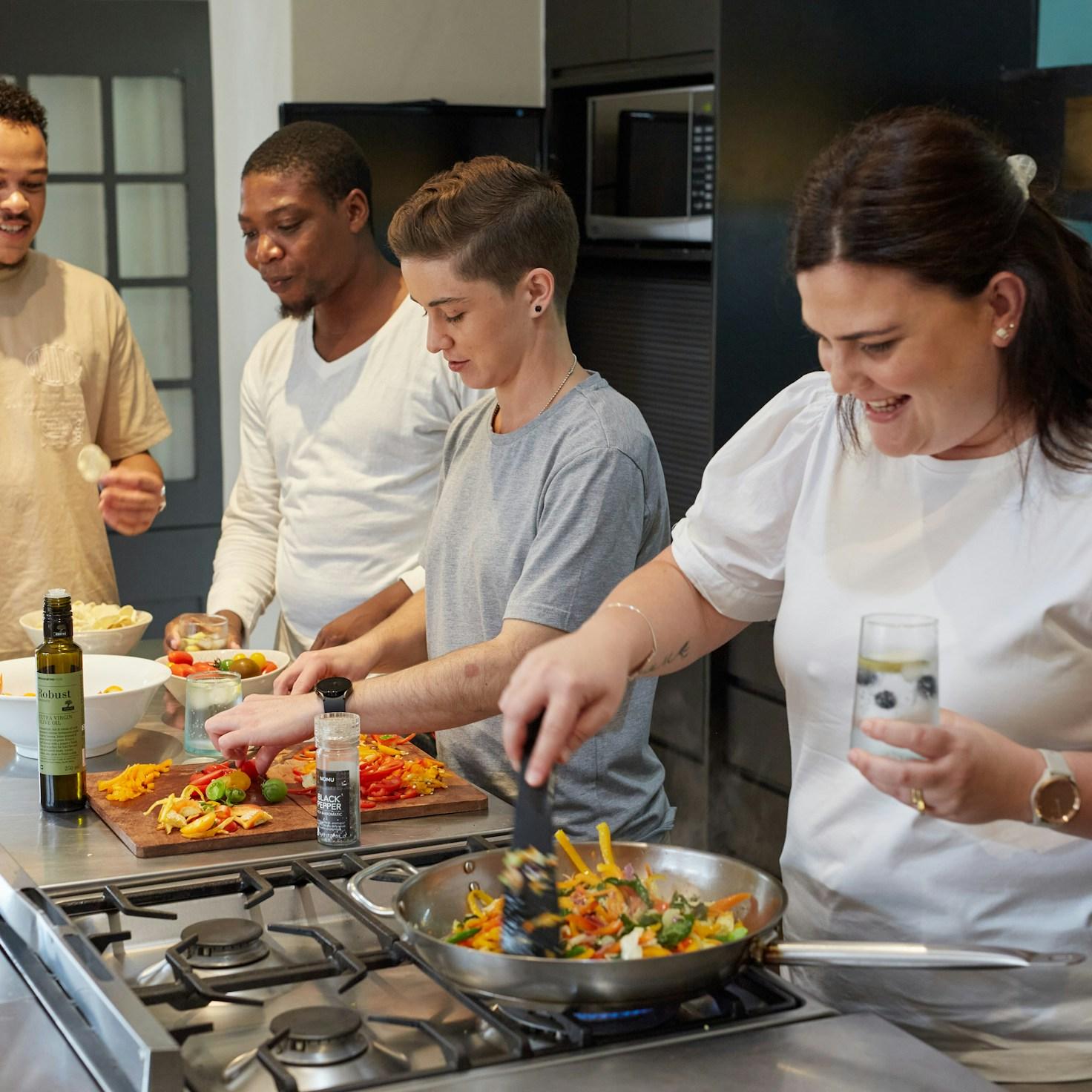 Diverse group of community members sharing a meal together, showcasing the social bonds formed through collaborative cooking